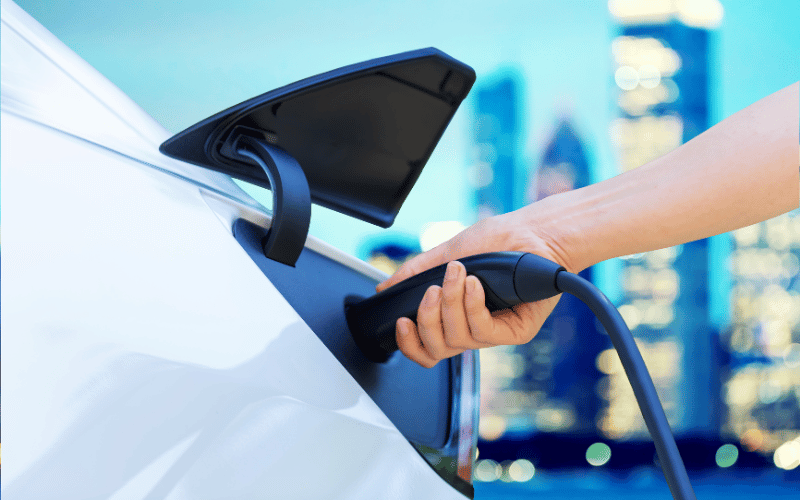 an image of a person charging an electric vehicle