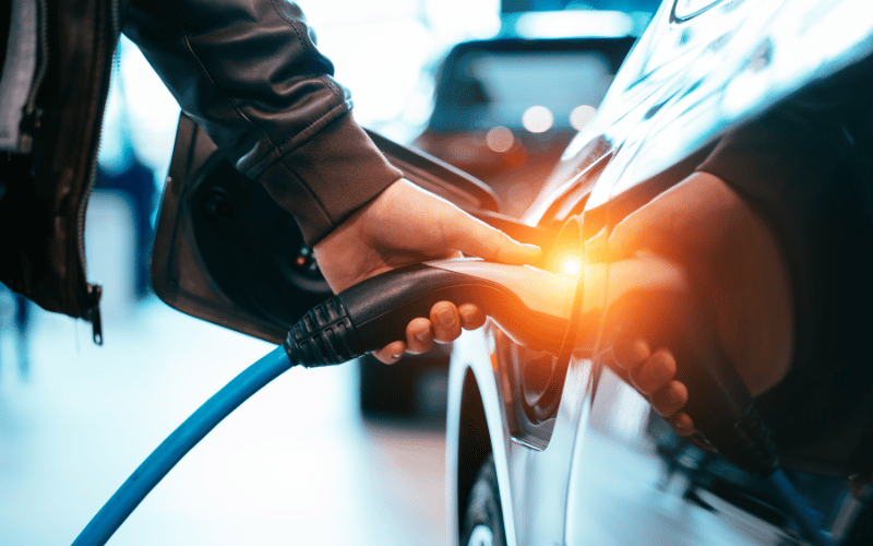 a person holding a charging cable for an electric vehicle