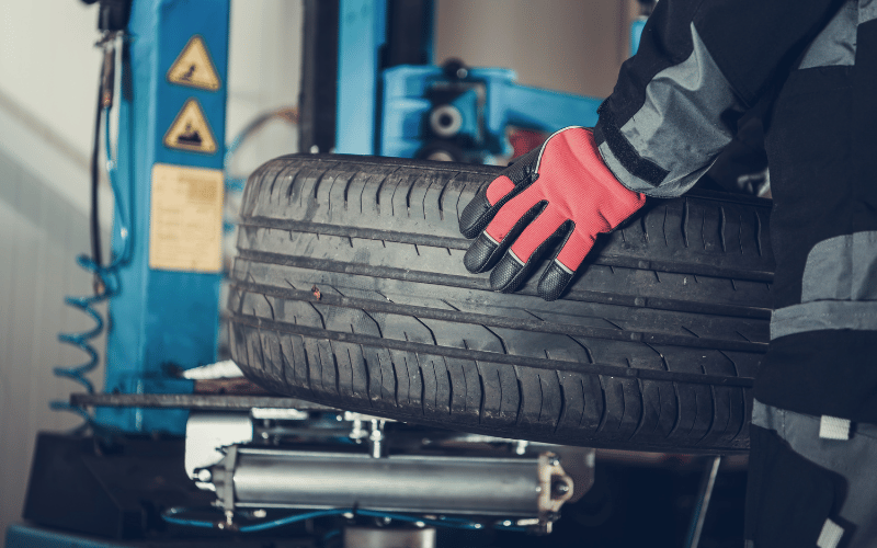 Car Tyres - man holding a big tyre